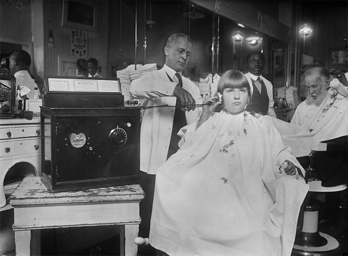 Boy listens to the radio in a barber shop in 1921.