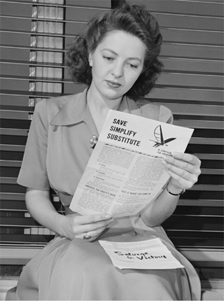 woman reads government information about rationing during World War II