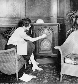 woman tuning a radio in 1920